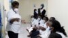 FILE - A health worker talks to colleagues as they prepare to receive a coronavirus vaccine at the Kenyatta National Hospital in Nairobi, Kenya, March 5, 2021. 