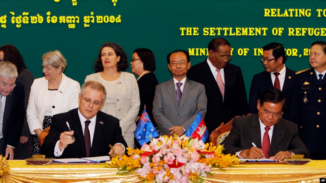 FILE - Australian Immigration Minister Scott Morrison signs a document together with Cambodian Interior Minister Sar Kheng on a deal for the resettlement of refugees, at the Interior Ministry in Phnom Penh, Sept. 26, 2014. 