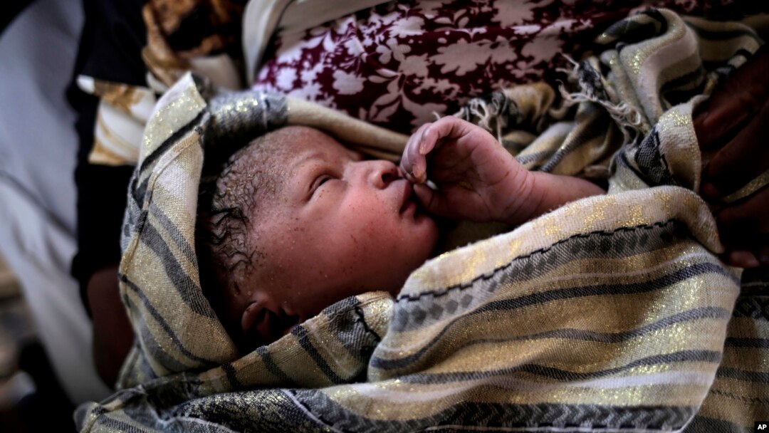 A newborn baby girl lays in her mothers' arms right after being born onboard a Spanish rescue vessel on the Mediterranean Sea, Sept. 6, 2017. A rescued woman from Ghana has given birth to a girl immediately after being rescued while trying to cross the Mediterranean Sea from Libya to Italy. 