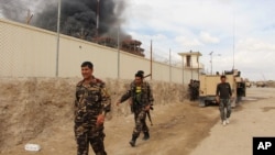 FILE - Smoke rises from a building, where Taliban insurgents hide during a firefight with Afghan security forces, in Helmand province, southwest Afghanistan, March 9, 2016.
