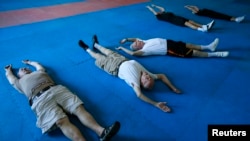 FILE - Parkinson's patients stretch as they begin their workout in Costa Mesa, California, Sept. 16, 2013. 