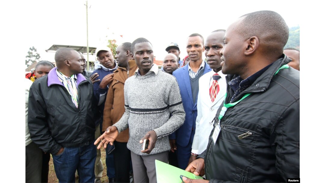 Igembe South parliamentary candidate on an Independent ticket John Paul Mwirigi, center, talks to his agents at their constituency tallying center in Maua Girls High School, in Maua, Kenya, Aug. 9, 2017.