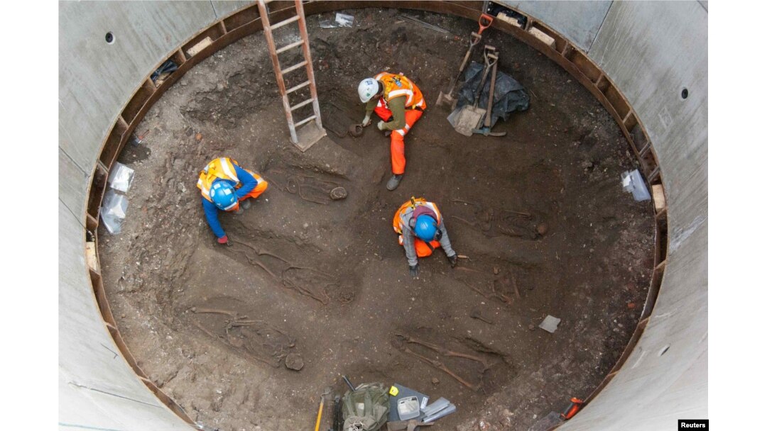 Archaeologists work on unearthed skeletons — possibly remains of Black Death victims — in the Farringdon area of London in this undated handout photo from March 2013.