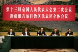 2019年3月12日在北京人民大會堂古董的全國人大會議新疆維吾爾自治區議會會議上，新疆黨委書記陳國民（中）講話。講台上的人前面都沒有名牌。