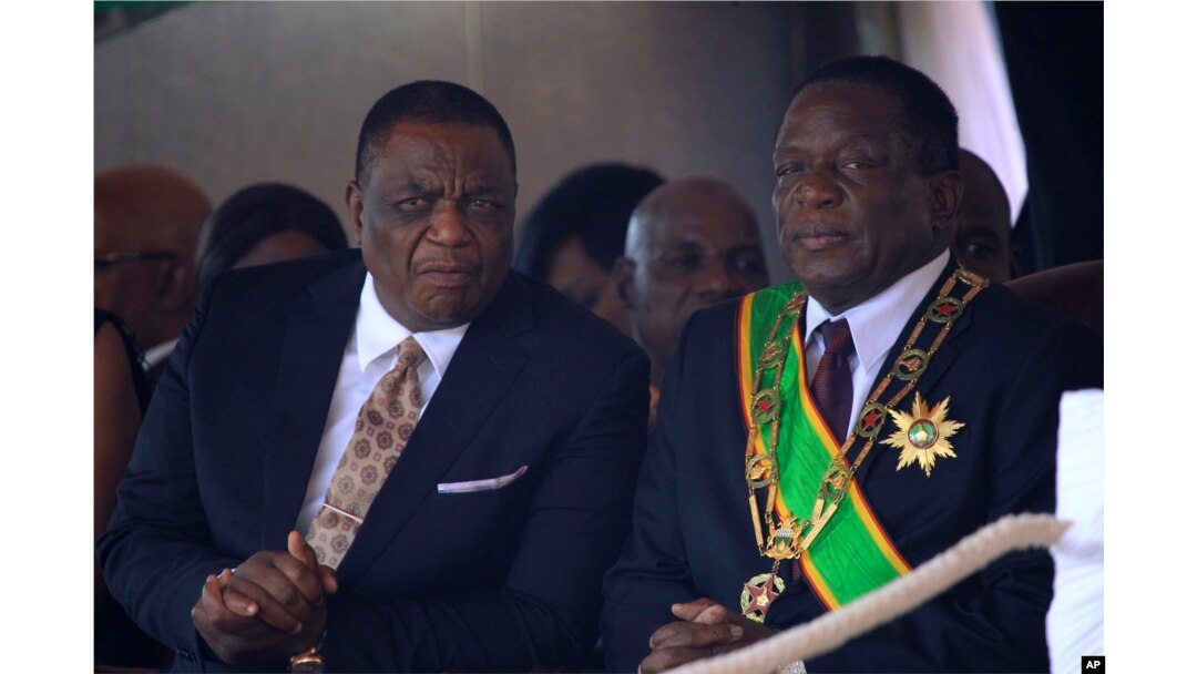 Zimbabwean President Emmerson Mnangagwa (R) sits with his Deputy Constantino Chiwenga during a Heroes' Day event to commemorate the lives of those who died in the southern African country's 1970s war against white minority rule, in Harare, Aug. 13, 2018.