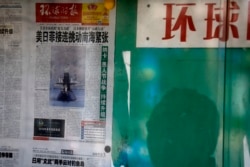 資料照：北京街頭一名男子在讀一處報欄裡張貼的環球時報。 （2016年4月5日）
