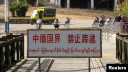 A sign on the bridge linking China with Myanmar warns people in the Chinese and Burmese languages not to cross over, at the Wanding border close to Ruili, Yunnan province, in this January 12, 2009 file photo.