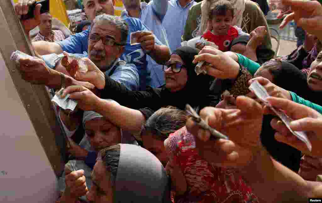 Egyptians gather to buy subsidized sugar from a government truck after a sugar shortage in retail stores across the country in Cairo, Egypt.