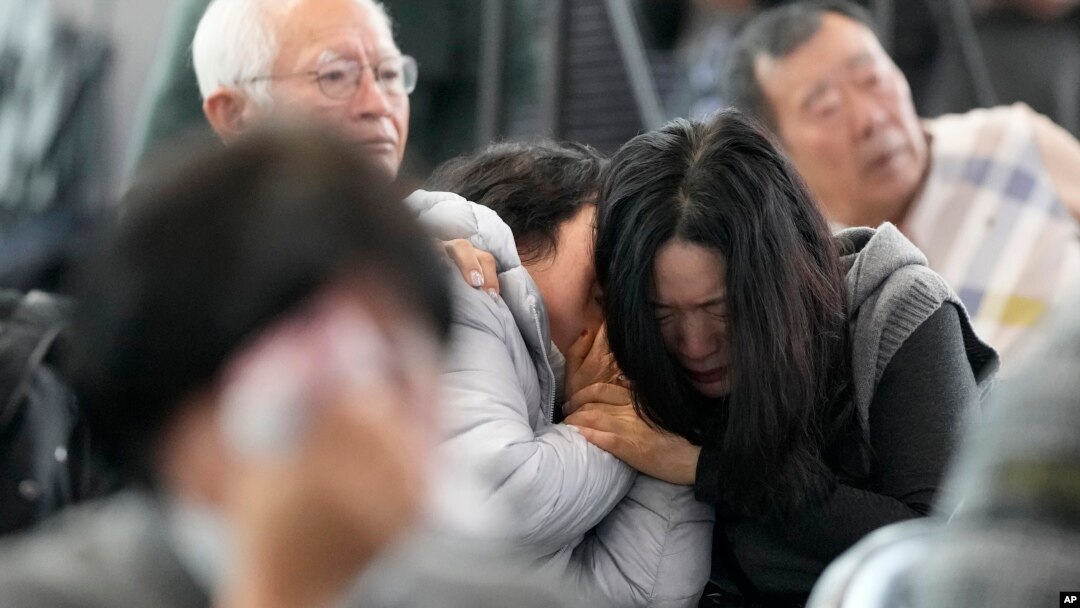 Relatives of passengers on a plane that burst into flames mourn at Muan International Airport in Muan, South Korea, Dec. 30, 2024.