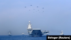 中國海軍遼寧號航母與軍艦和戰機在進行軍事表演。（2018年4月12日）