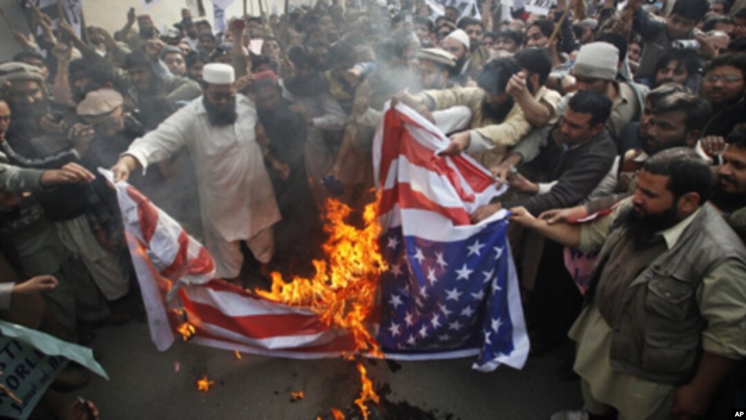 Supporters of religious parties burn a U.S flag during a protest against detained U.S. citizen Raymond Davis in Lahore, February 18, 2011.