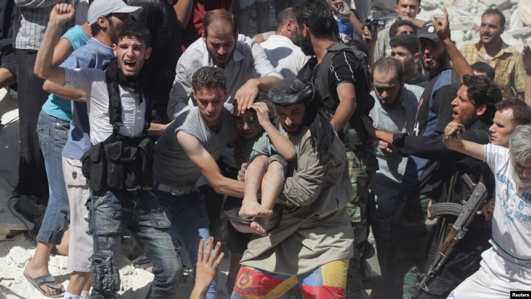 Free Syrian Army fighters and civilians help a wounded boy rescued from under rubble after what activists said was shelling by forces loyal to Syria's President Bashar al-Assad in Aleppo's Bustan al-Qasr district, Aug. 16, 2013.
