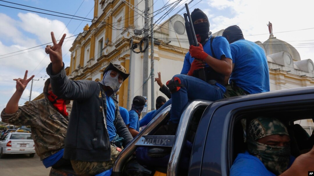 Armed pro-government militia members flash victory signs as they occupy the Monimbo neighborhood of Masaya, Nicaragua, July 18, 2018. 
