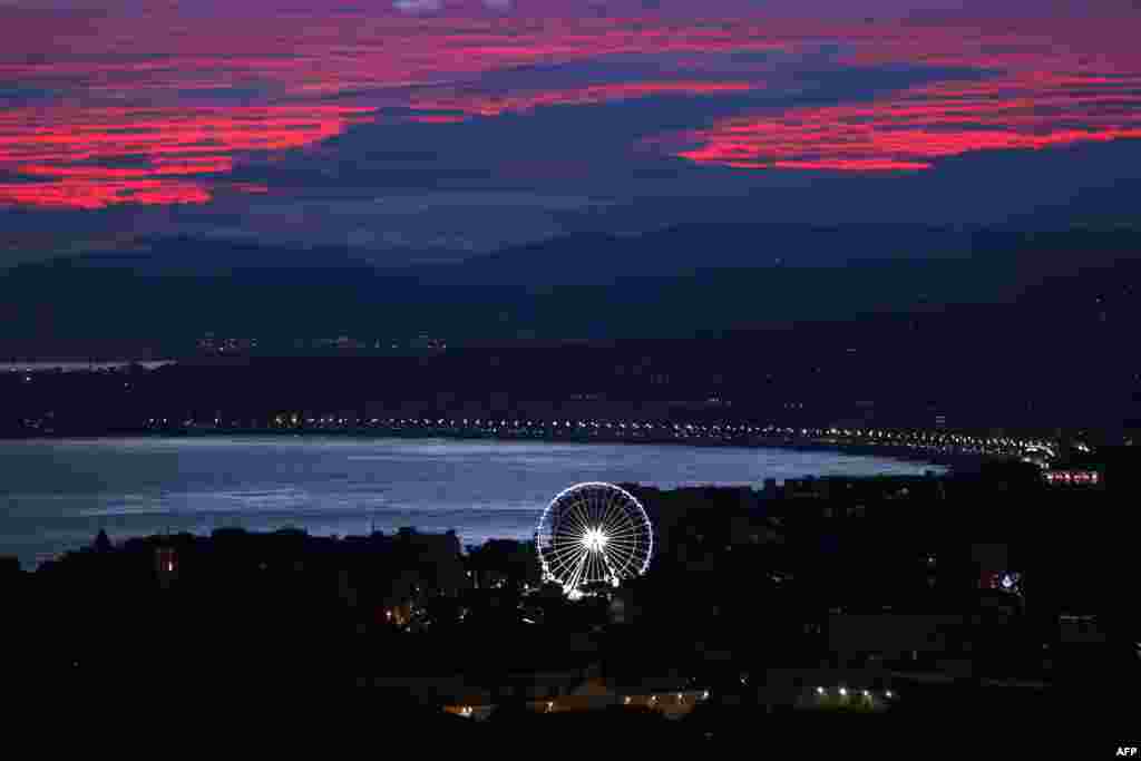 A ferris wheel is illuminated as the sun sets over the French Riviera city of Nice, southeastern France, on Dec. 2, 2018.