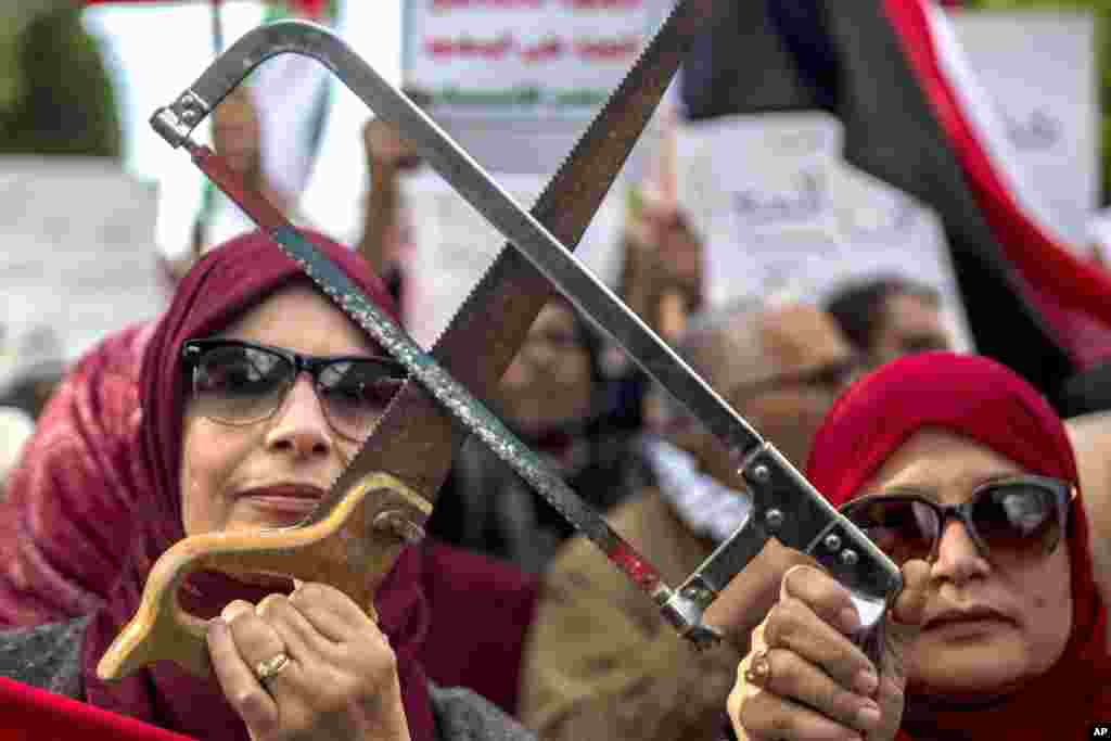Protesters holding saws gather in Tunis, Tunisia, to demonstrate against the visit of Saudi Arabia's Crown Prince Mohammed bin Salman amid international concern about the killing of Saudi journalist Jamal Khashoggi.