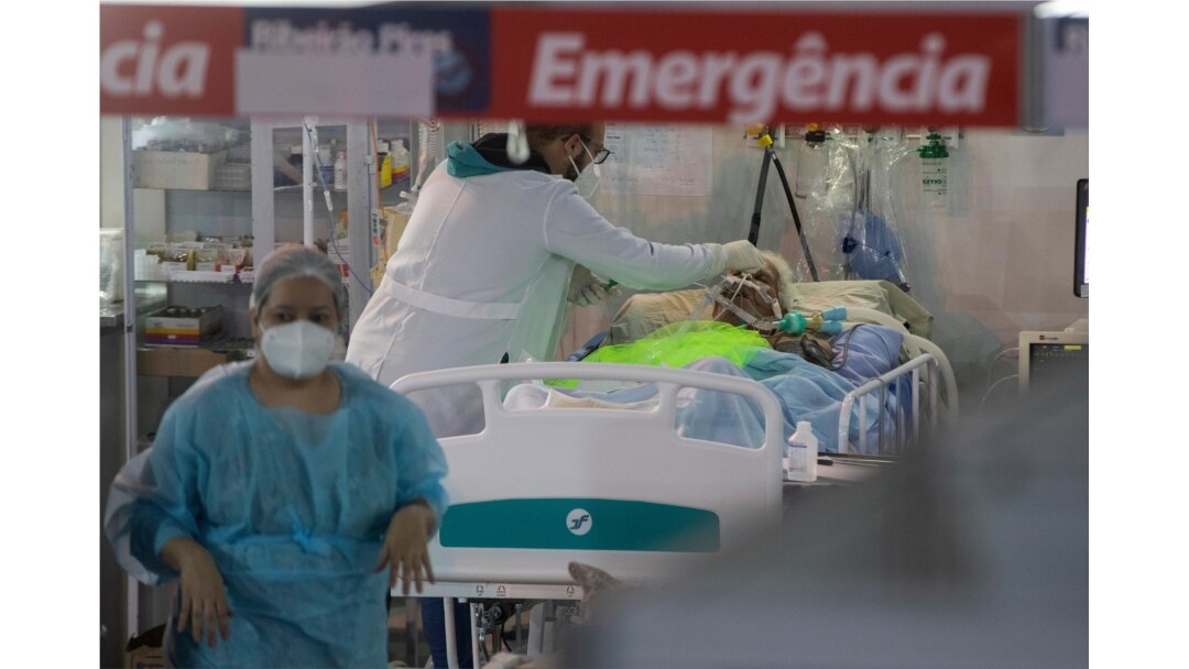 FILE - Health workers treat a COVID-19 patient at the emergency unit of a field hospital set up to treat COVID patients in Ribeirao Pires, greater Sao Paulo area, Brazil, April 13, 2021.