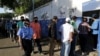 ARCHIVO - Una mujer policía pasa junto a personas que hacen cola para ingresar a una escuela utilizada como mesa de votación, para emitir su voto durante las elecciones presidenciales de Nicaragua en Managua, Nicaragua, el 7 de noviembre de 2021. REUTERS/Stringer
