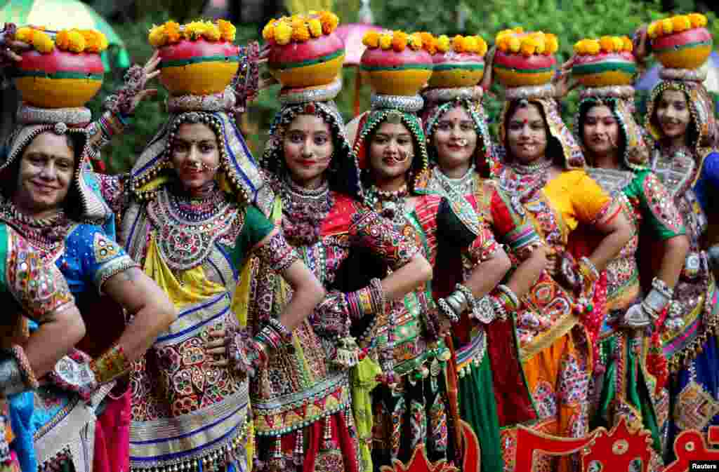 Women pose for pictures during rehearsals for Garba, a folk dance, ahead of Navratri, a festival during which devotees worship the Hindu goddess Durga and youths dance in traditional costumes, in Ahmedabad, India.