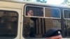 Arhiva - Policajac stoji ispred autobusa sa novinarima uhapšenim tokom mitinga u Moskvi, 7. jula 2019.