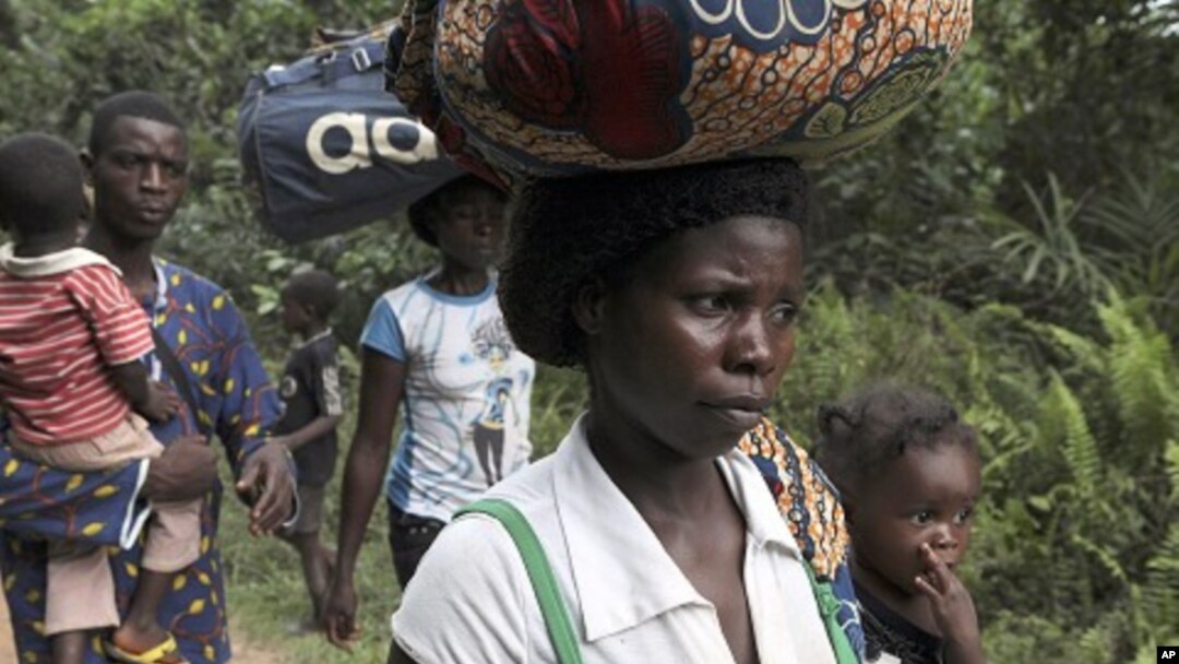 Refugees from Ivory Coast walk with their their belongings through Grand Gedeh county in eastern Liberia March 23, 2011.