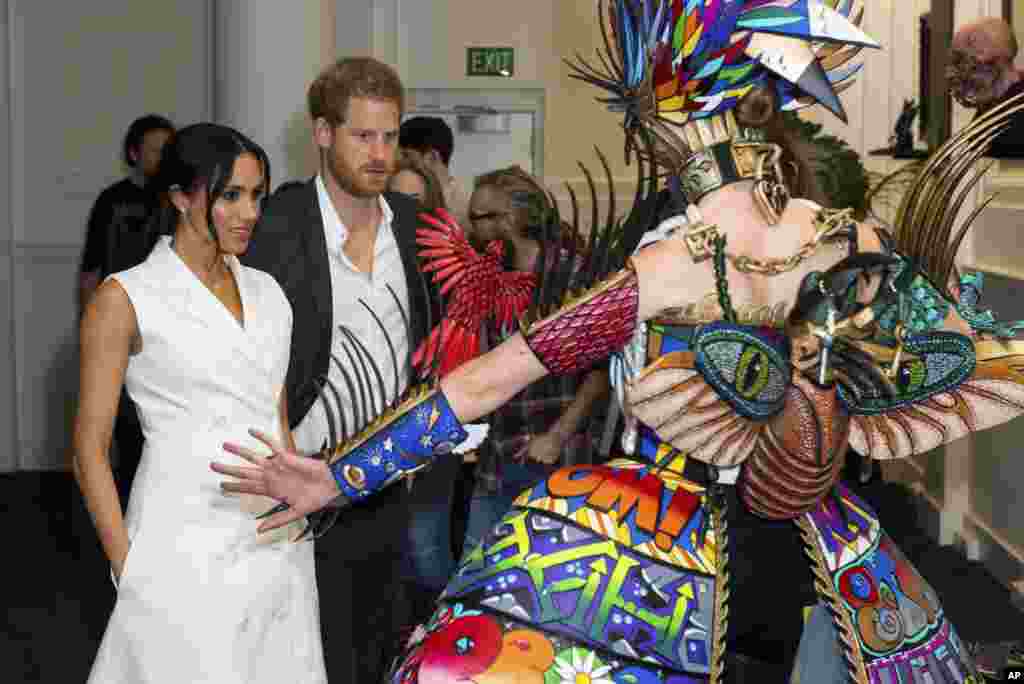 Britain's Prince Harry and Meghan, Duchess of Sussex, meet actors in costume during a visit to Courtenay Creative in Wellington, New Zealand.