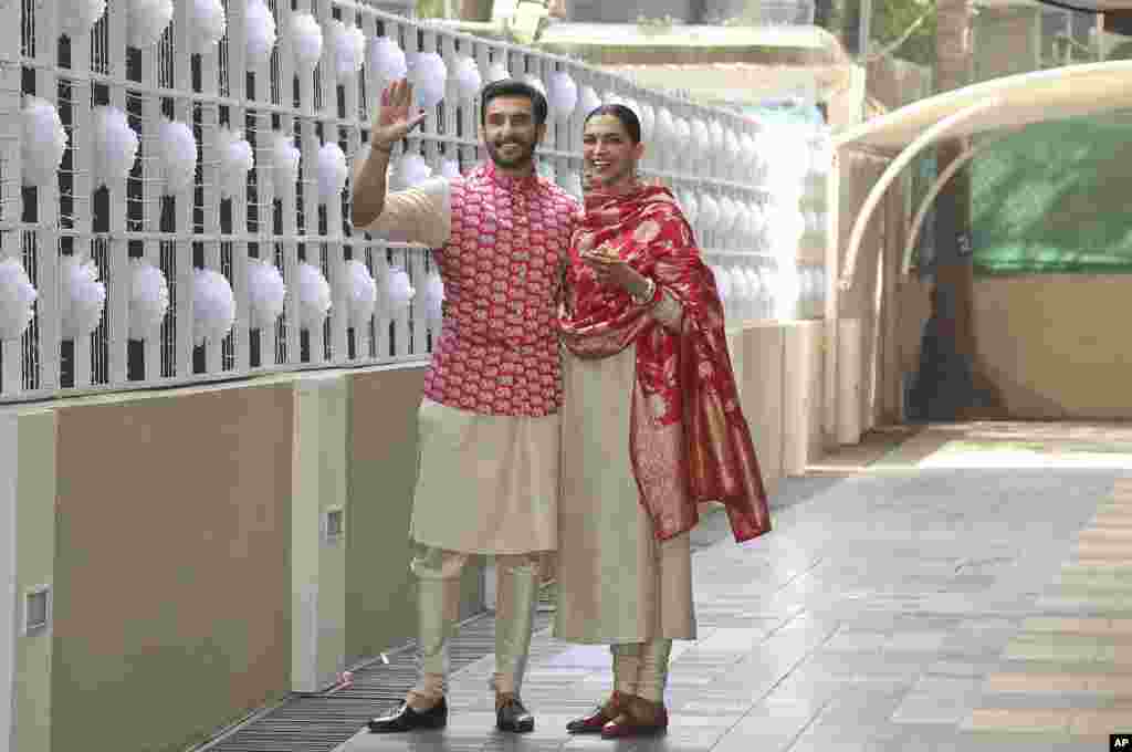 Newlywed Bollywood stars Deepika Padukone and Ranveer Singh, left, pose for the media outside their home in Mumbai, India, after returning from their wedding in Italy.