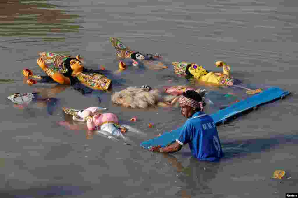 A devotee immerses an idol of the Hindu goddess Durga into the Ganges river on the last day of the Durga Puja festival in Kolkata, India.