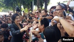 FILE -Ousted former Thai Prime Minister Yingluck Shinawatra greets supporters as she leaves the Supreme Court in Bangkok, Thailand, Aug. 1, 2017. 