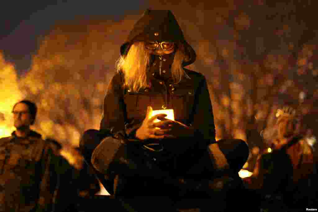 A woman holds a candle at a vigil for the victims of the fatal warehouse fire in Oakland, California, Dec. 5, 2016.