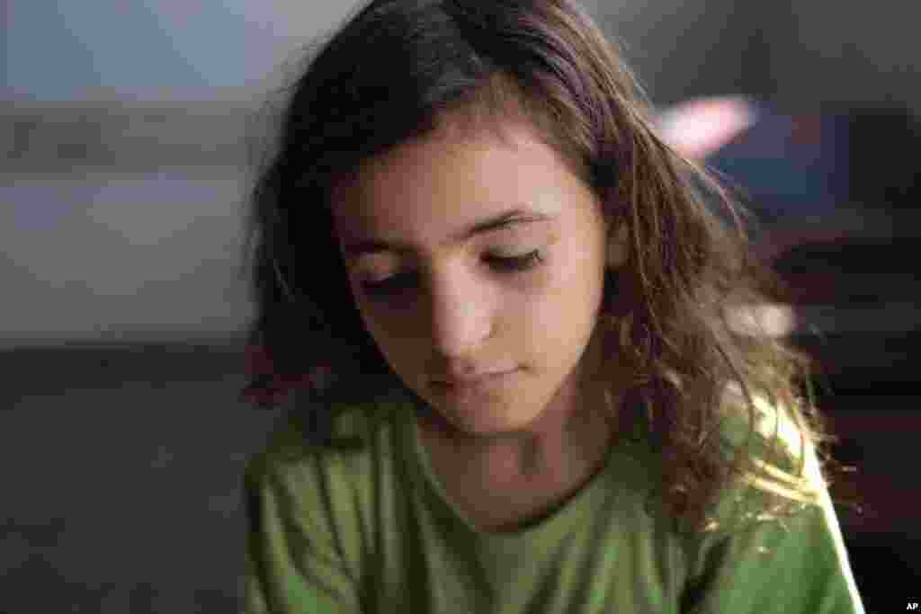 Displaced Palestinian Yasmine Omar Al Attar, 10, sits at a U.N. school where the family had sought refuge during the war in Gaza City, northern Gaza Strip, Aug. 6, 2014.