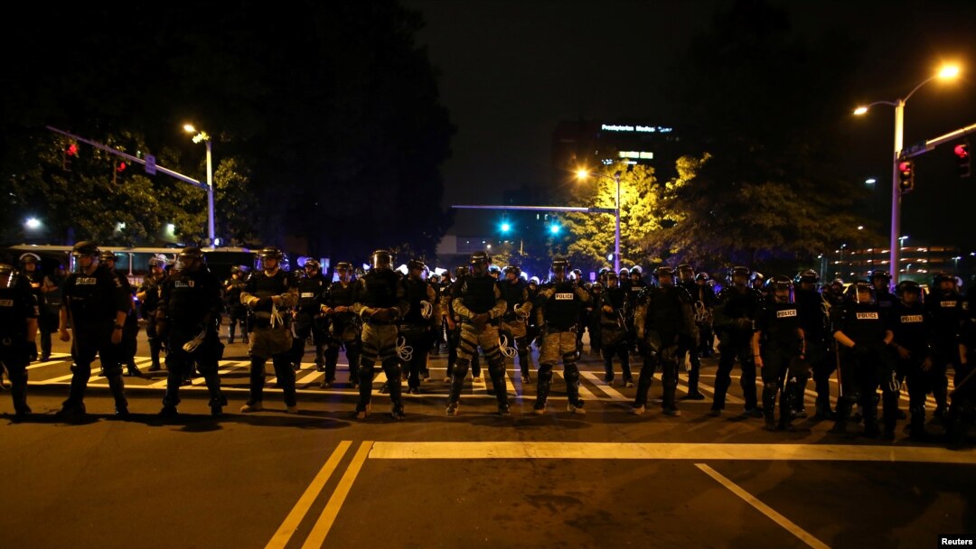 Police in riot gear block a roadway to stop demonstrators from entering a neighborhood as they protest the police shooting of Keith Scott in Charlotte, North Carolina, U.S., September 25, 2016.