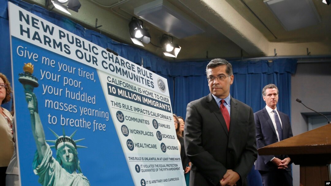 California Attorney General Xavier Becerra, left, outlines the supposed effects on immigrants under the Trump administration's new rules blocking green cards for many of those who receive government assistance, in Sacramento, Calif., Aug. 16, 2019. 