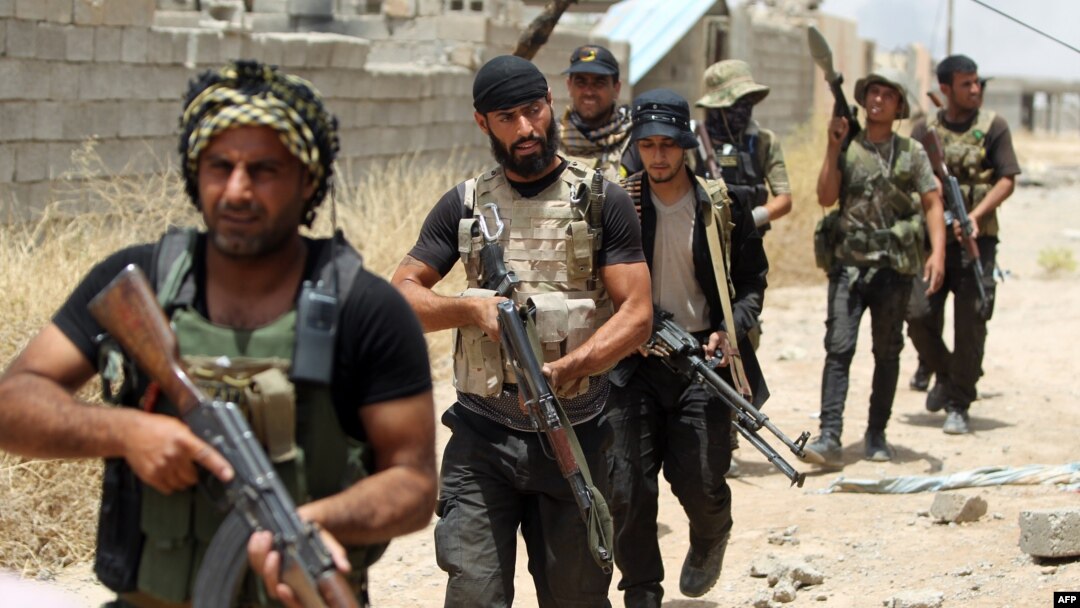Iraqi Shi'ite fighters from the Popular Mobilization units deploy in the city of Baiji, north of Tikrit, as they fight alongside Iraqi forces against the Islamic State jihadist group to try to retake the strategic town for a second time, June 9, 2015. 
