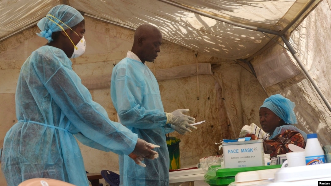 Health workers take blood samples for Ebola virus testing at a screening tent in the local government hospital in Kenema, Sierra Leone, June 30, 2014. 