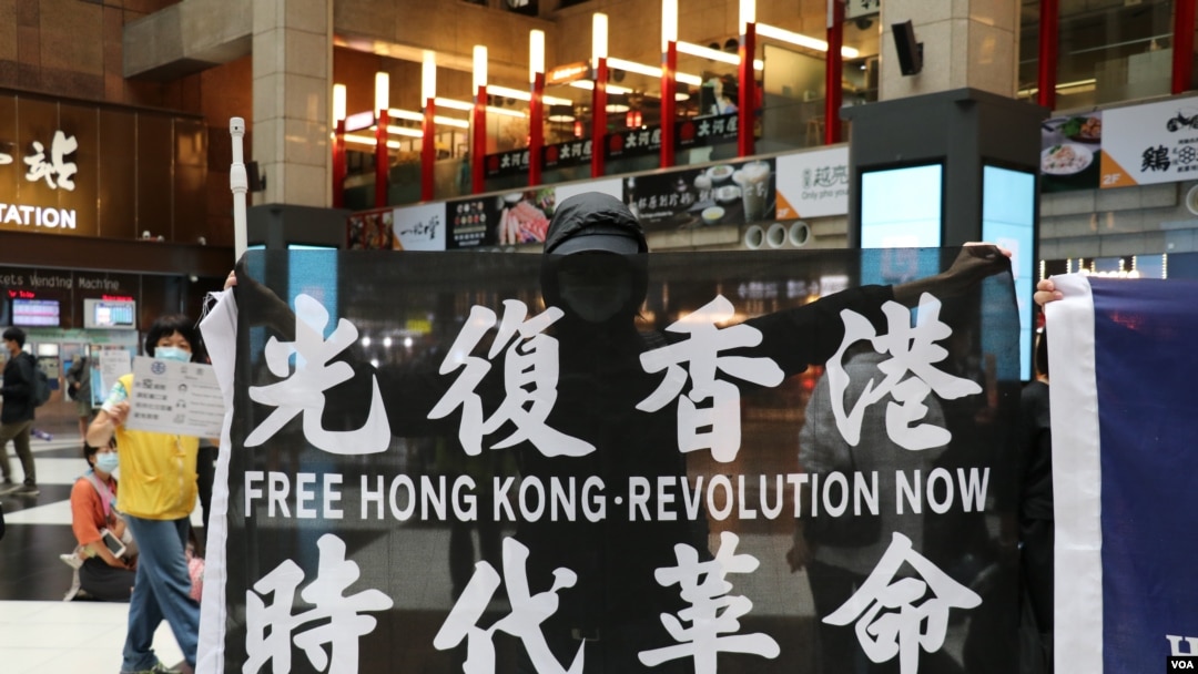 資料照：在台北車站參與支持香港行動的民眾高舉“光復香港時代革命”旗幟。 （2020年5月23日）